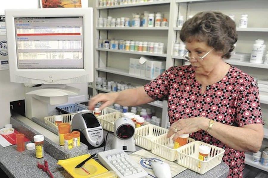 Pharmacy technician Marie Shultz retrieves and caps filled prescriptions at Mac's Pharmacy.