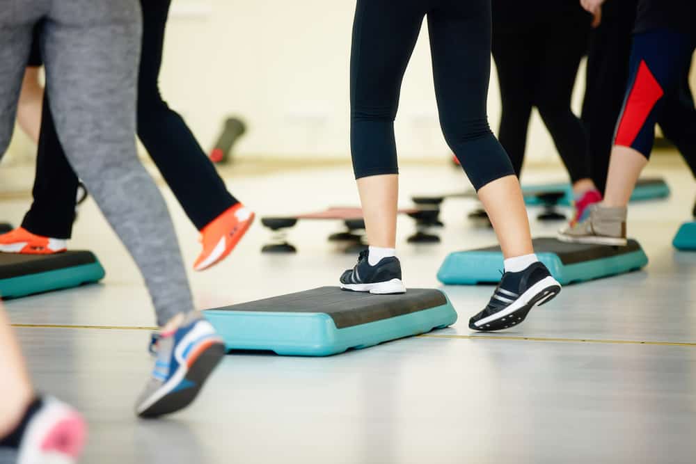 people doing step aerobics in gym