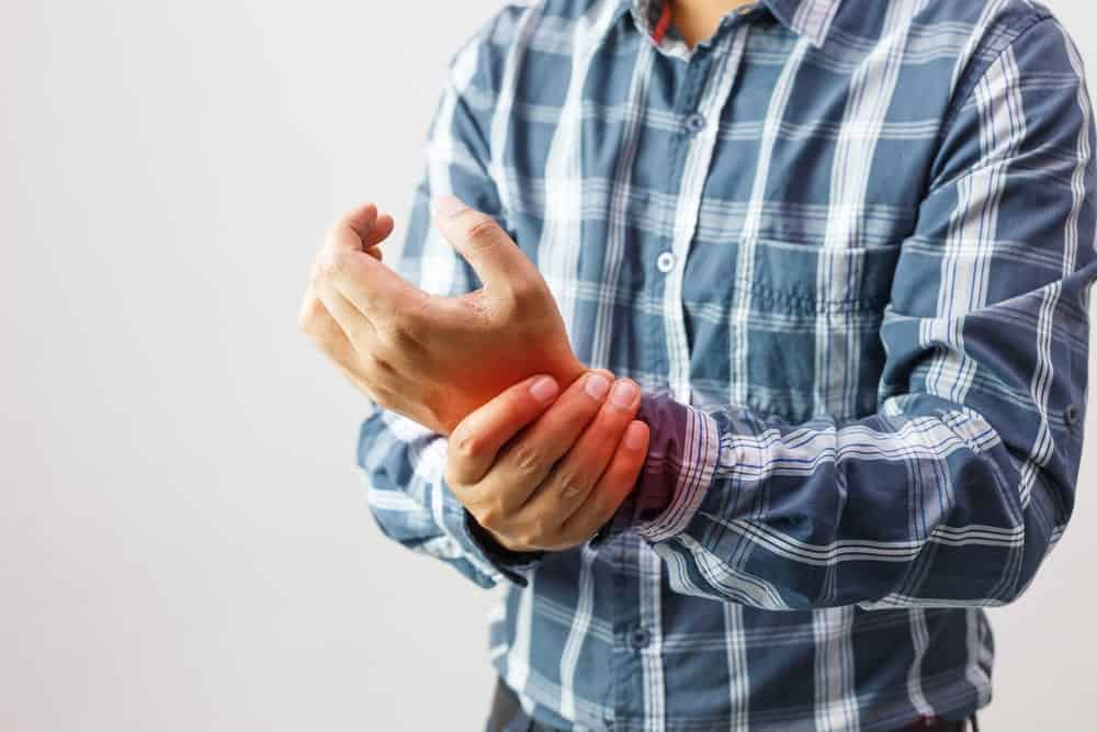 a man holding his hand with arthritis