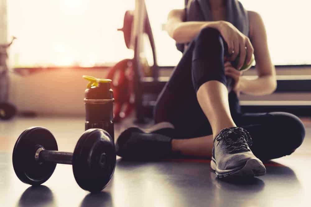 Woman exercising with weight and water bottle