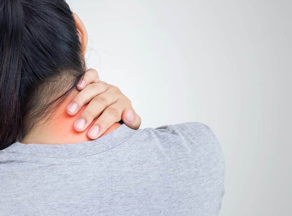 woman holding neck in pain