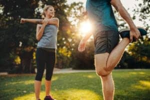 woman and man stretching before going on a run